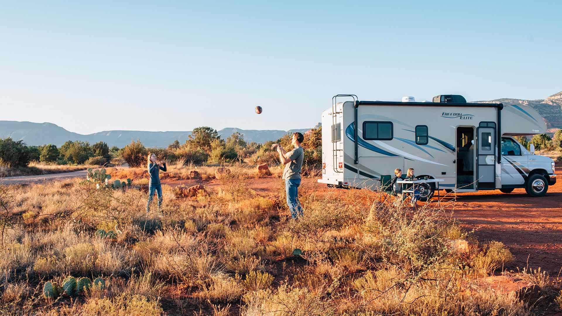 Two people playing near parked RV